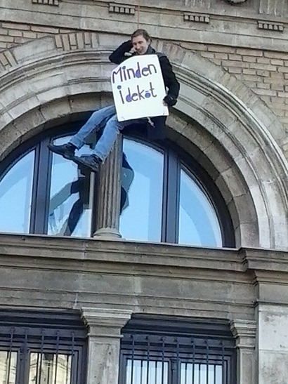 Miért egy olvashatatlan táblát tartó hahás aktivistát kötöttek fel az egyetem homlokzatára?