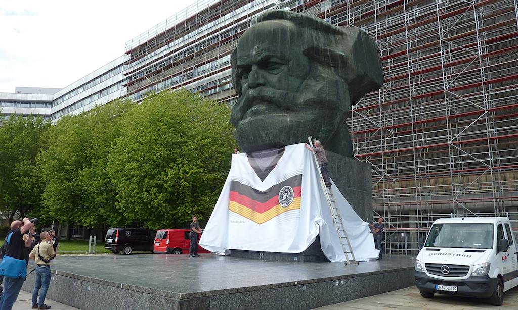 Illustration for article titled Csütörtökön kezdődik a focivébé, német színekbe öltöztették Marxot
