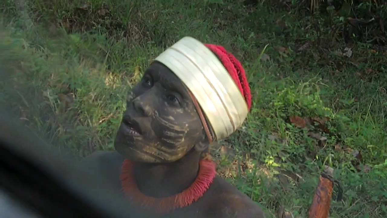 Jarawa férfit cukorral kínálnak egy busz ablakából.